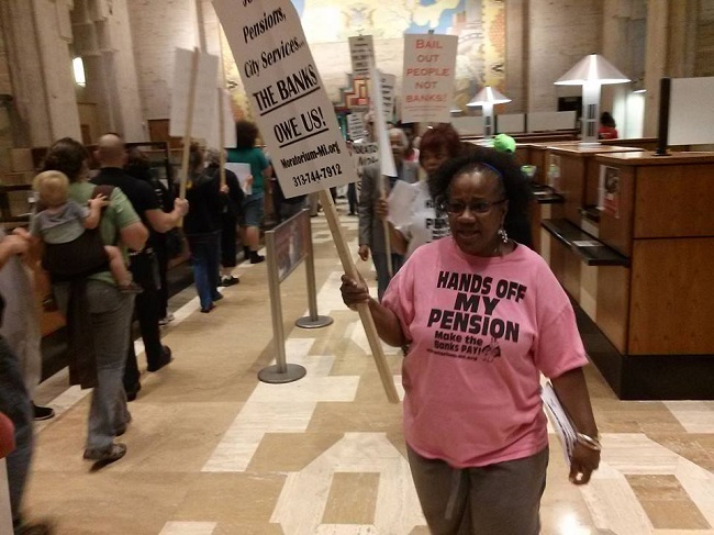 Demonstrators march inside the Bank of American branch in the Guardian Building during Freedom Friday 6, June 13, 2014.